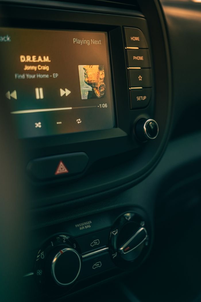 Close-up of a car dashboard featuring a modern stereo system playing music.