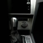 Close-up of a modern car's interior featuring the gear shift and digital dashboard display.