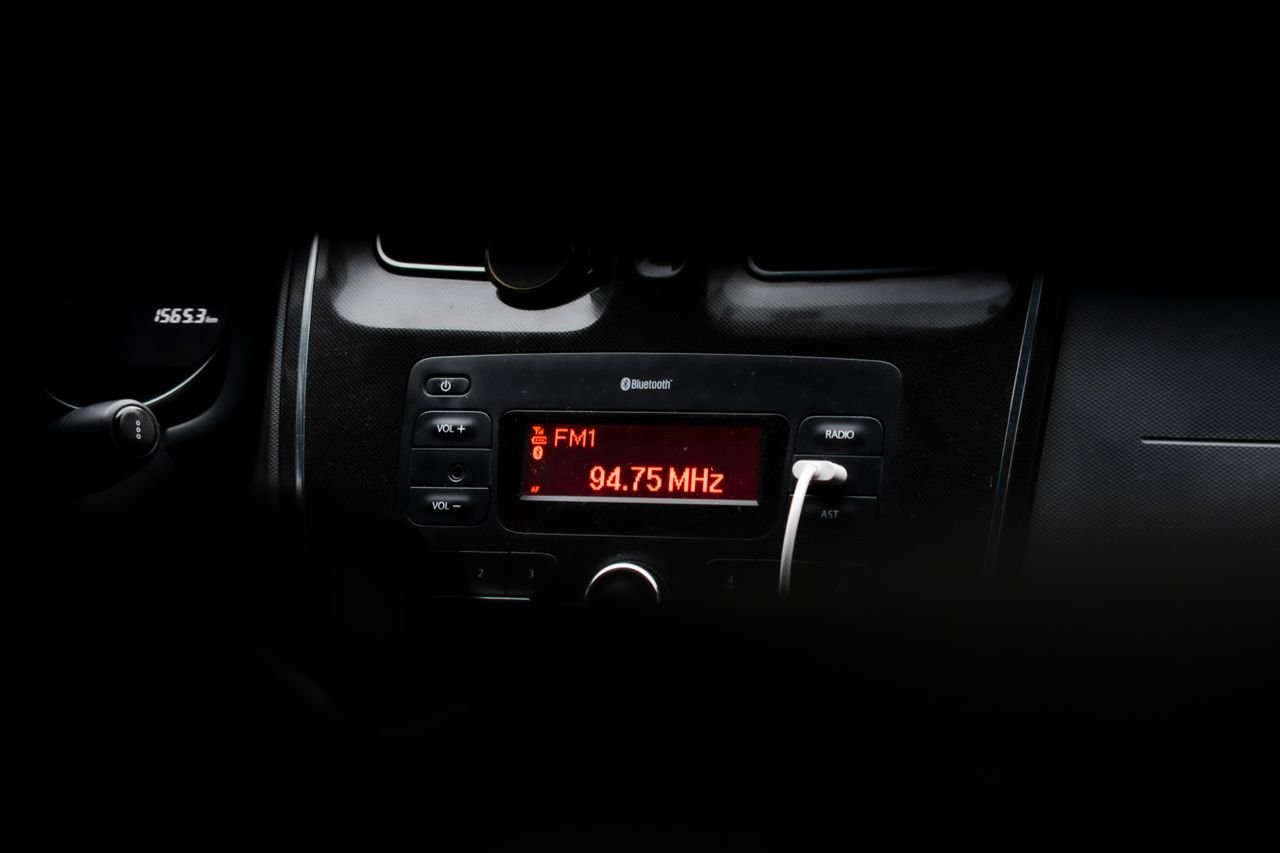 A detailed image of a car's dashboard showing a radio display with red LED lights.
